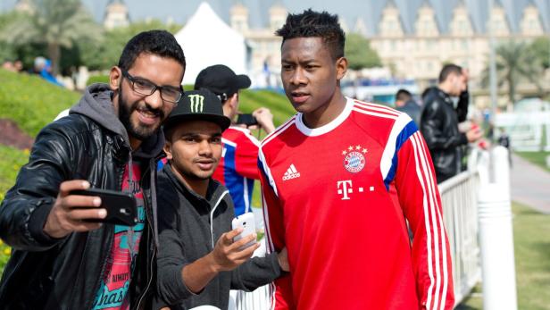 David Alaba posiert mit Fans für ein Selfie.