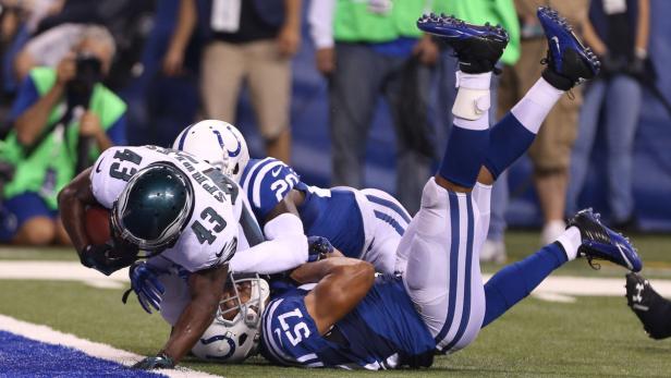 Ein Footballspieler der Philadelphia Eagles wird von zwei Spielern der Indianapolis Colts getackelt.