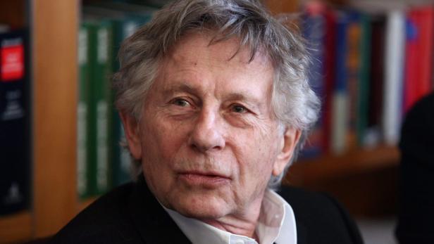 Nahaufnahme des Regisseurs Roman Polanski vor einem Bücherregal.