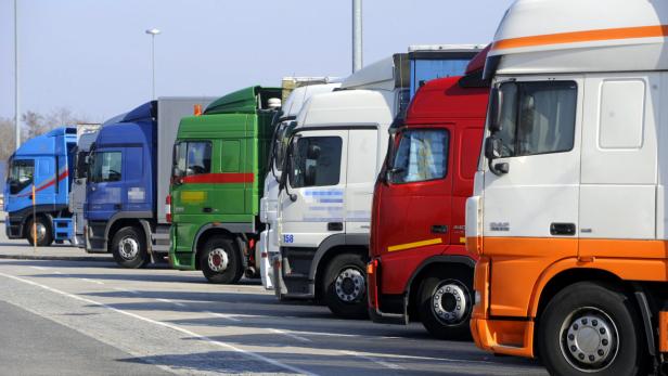 Mehrere Lastwagen unterschiedlicher Farben stehen in einer Reihe.