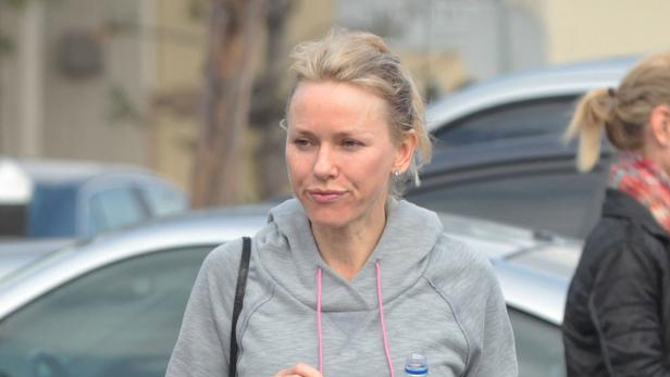Naomi Watts trägt einen grauen Hoodie und hält eine Wasserflasche.