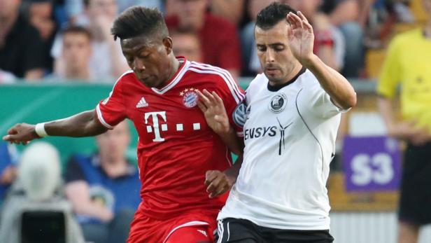 Zwei Fußballspieler kämpfen um den Ball.