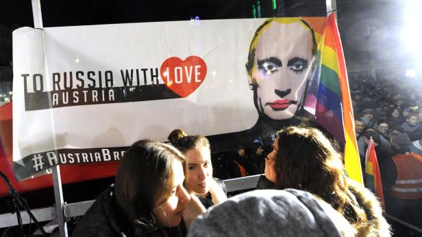 Demonstration mit einem Plakat „To Russia with Love, Austria“ und einem stilisierten Porträt von Putin mit Regenbogenflagge.