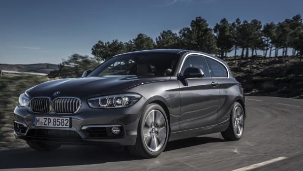 Ein grauer BMW fährt auf einer kurvigen Straße.