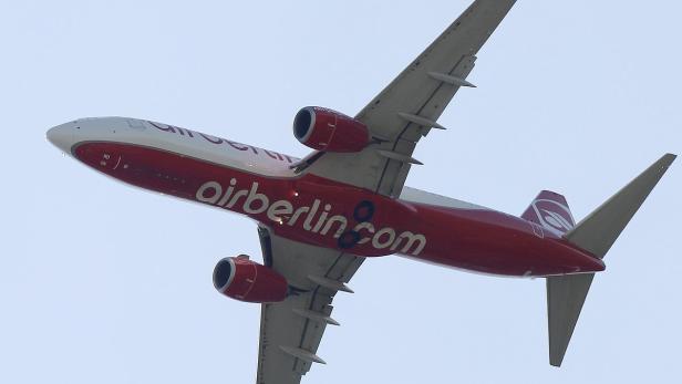 Ein rot-weißes Flugzeug von Air Berlin steigt in den Himmel auf.