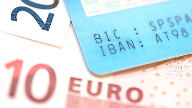 Ein Zehn-Euro-Schein, ein Zwanzig-Euro-Schein und eine Bankkarte mit IBAN und BIC liegen übereinander.