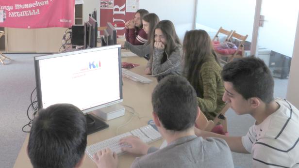 Eine Gruppe von Schülern arbeitet an Computern in einem Klassenzimmer.