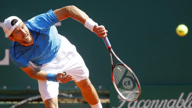 Ein Tennisspieler schlägt einen Ball mit seinem Schläger.