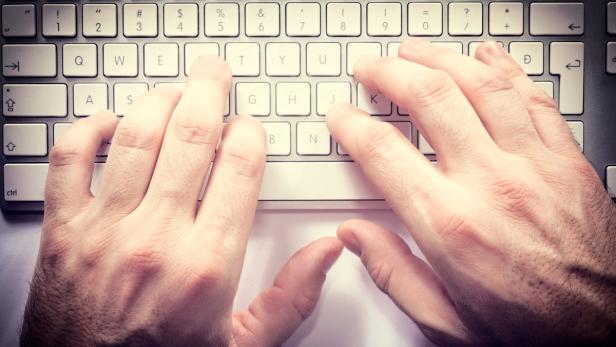 Typing hands on the ketboard from above