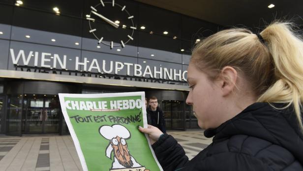 Eine Frau liest vor dem Wiener Hauptbahnhof eine Ausgabe von „Charlie Hebdo“.