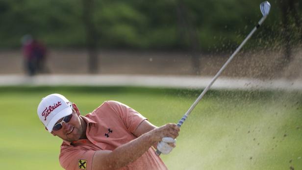 Ein Golfspieler schlägt einen Ball aus einem Sandbunker.