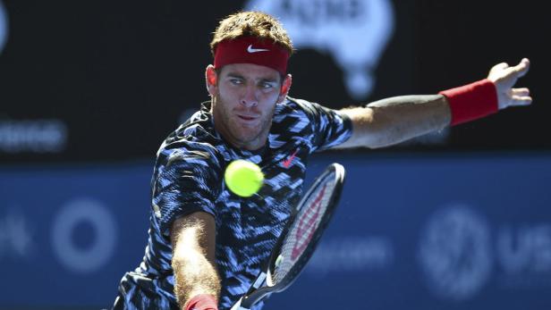 Ein Tennisspieler mit rotem Stirnband schlägt einen gelben Tennisball.