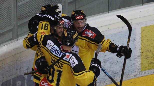 Eishockeyspieler in gelb-schwarzen Trikots feiern ein Tor.