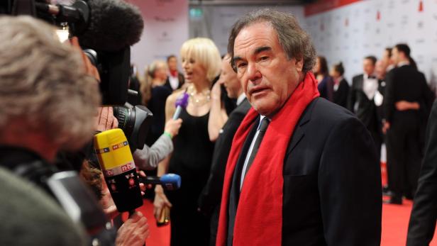 Oliver Stone wird auf dem roten Teppich von Reportern interviewt.