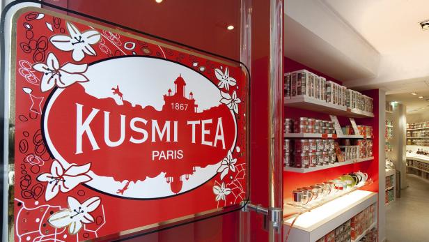 Ein Schild mit der Aufschrift „Kusmi Tea Paris“ vor einem Teeladen.