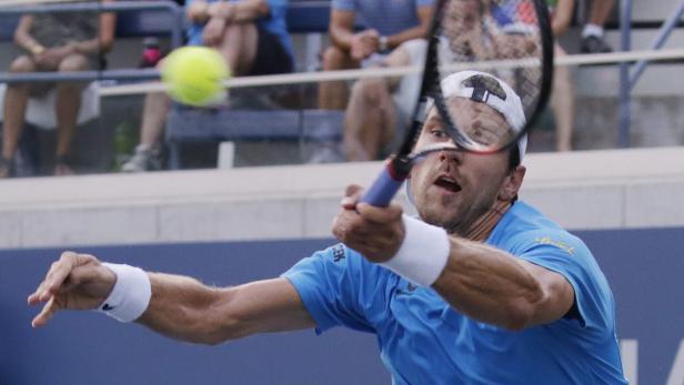 Ein Tennisspieler schlägt einen Ball während eines Matches.