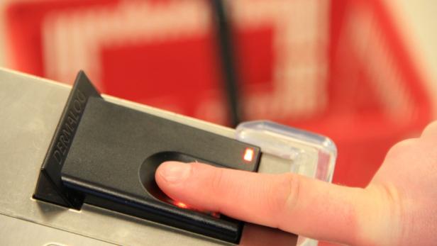 DERMALOG präsentiert innovatives Fingerabdruck-Bez Ein Finger wird auf einen Fingerabdruckscanner der Marke Dermaloc gelegt.