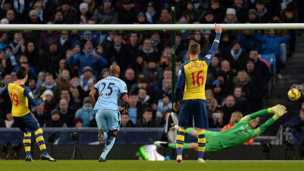 Ein Fußballspiel mit Spielern in gelben und hellblauen Trikots vor einer Zuschauermenge.