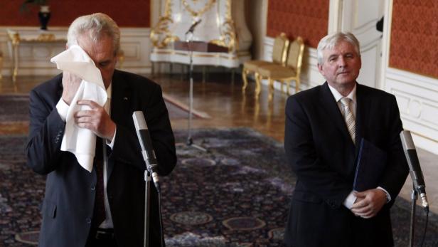 Czech President Milos Zeman wipes his face after he appointed JIri Rusnok (R) as new prime minister at Prague Castle June 25, 2013. Rusnok will replace Petr Necas who resigned last week in a bribery and spying scandal involving a close aide. REUTERS/Petr Josek (CZECH REPUBLIC - Tags: POLITICS)