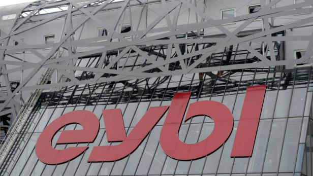 Das rote „eybl“-Logo an einem modernen Gebäude mit Glasfassade.