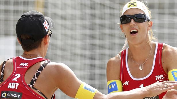 Zwei Beachvolleyballspielerinnen des österreichischen Teams klatschen sich ab.