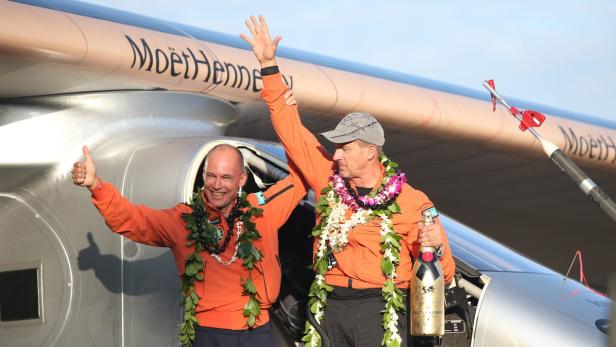 André Borschberg und Bertrand Piccard feiern vor dem Solarflugzeug „Solar Impulse“.