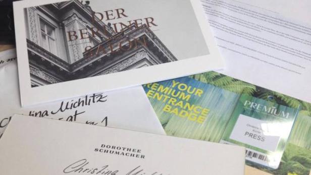 Einladung zum „Berliner Salon“ und Premium-Ausweise liegen auf einem Tisch.