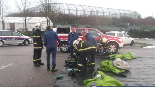 Feuerwehrleute rüsten sich mit Schutzbekleidung zum Gaseinsatz aus