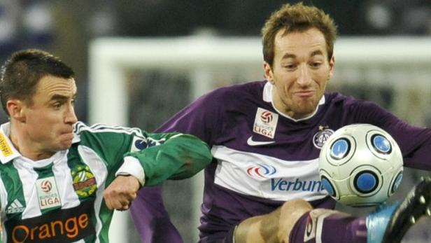 Zwei Fußballspieler kämpfen um den Ball während eines Spiels.