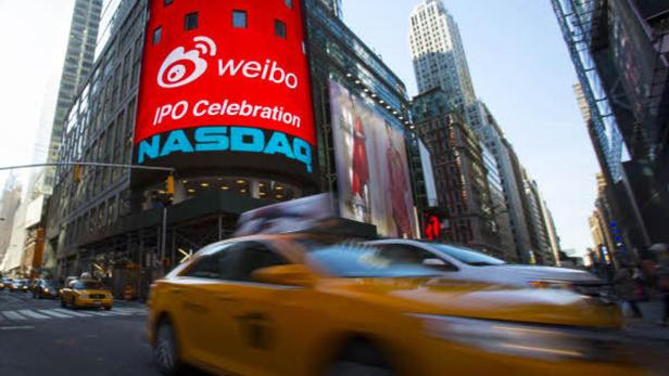 Ein gelbes Taxi fährt vor einem Gebäude mit einer „Weibo“-Werbung in New York City vorbei.