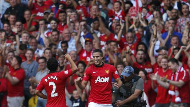 Robin van Persie jubelt mit Rafael vor einer jubelnden Menge im roten Manchester United Trikot.