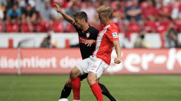 Zwei Fußballspieler kämpfen um den Ball während eines Spiels.