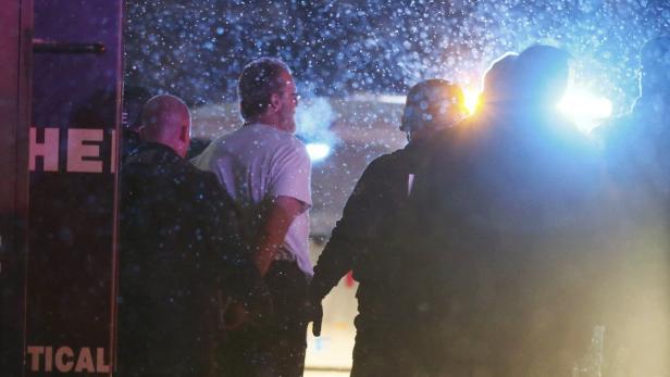 A suspect is taken into custody outside a Planned Fünf Stunden dauerte die Schießerei in Colorado.
