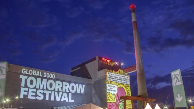 Das „Tomorrow Festival“ auf einem Fabrikgelände mit hohem Schornstein bei Nacht.