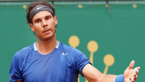 Rafael Nadal auf einem Tennisplatz, mit einem Stirnband und Tape an den Fingern.