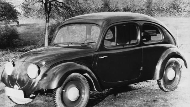 Ein schwarzes Auto der 1930er Jahre steht im Freien.
