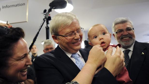 epa03821461 Australian Prime Minister Kevin Rudd (C) holds five-month-old Patrick Wilkinson during an election campaign visit to the hearing hub at Macquarie University in the electorate of Bennelong, in Sydney, Australia, 12 August 2013. Australia will hold federal elections on 07 September. EPA/LUKAS COCH AUSTRALIA AND NEW ZEALAND OUT
