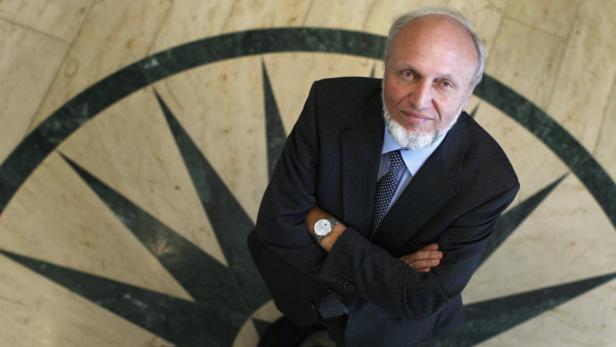 Ein Mann im Anzug steht vor einem Kompassmuster auf dem Boden.