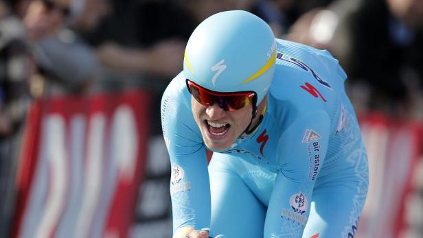 Ein Radrennfahrer mit blauem Trikot und Helm fährt ein Rennen.