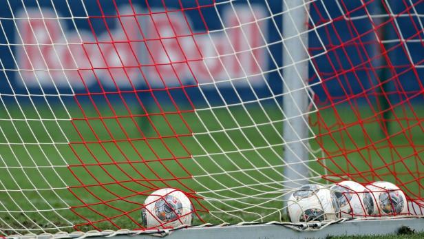 Mehrere Fußbälle liegen im Netz eines Fußballtors.