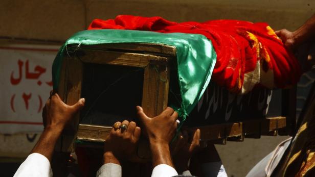 Mourners carry the coffin of victim killed by a ca