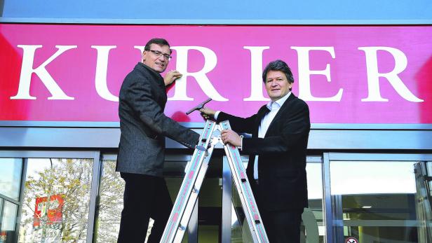 KURIER-Geschäftsführer Thomas Kralinger und Chefredakteur Helmut Brandstätter befestigen den neuen KURIER-Schriftzug.
