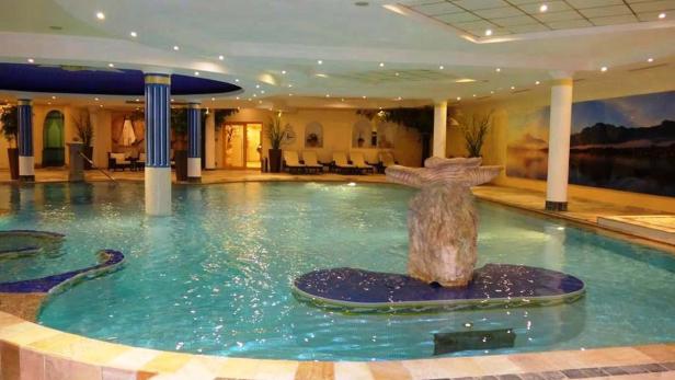 Ein Innenpool mit einer dekorativen Felsformation in der Mitte.