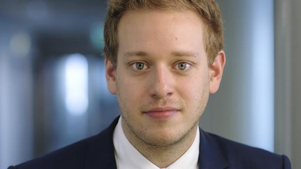 Porträt eines jungen Mannes in Anzug und Krawatte.