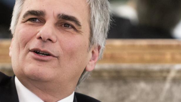 Ein Mann mit grauem Haar und dunklem Anzug spricht.