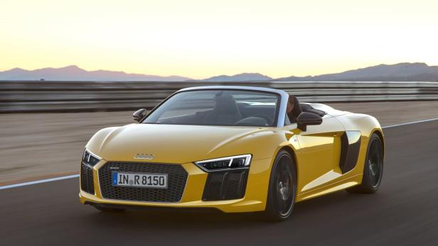 Ein gelber Audi R8 Spyder fährt auf einer Rennstrecke.