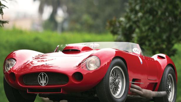 Ein roter Maserati-Rennwagen steht auf einer Straße.
