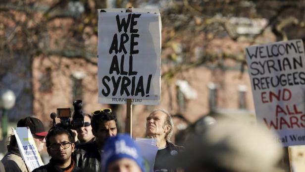 Jim McMahan of Seattle holds a "We are all Syria"