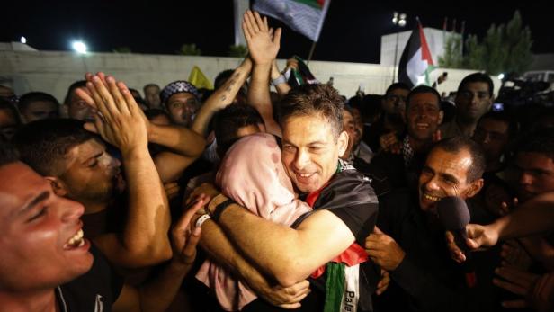 A freed Palestinian prisoner hugs a relative after his arrival in the West Bank city of Ramallah August 14, 2013. Israel freed 26 Palestinian prisoners on Wednesday to keep U.S.-sponsored peacemaking on course for a second round of talks, but diplomacy remained dogged by Israeli plans for more Jewish homes on land the Palestinians claim for a future state. REUTERS/Mohamad Torokman (WEST BANK - Tags: POLITICS TPX IMAGES OF THE DAY)