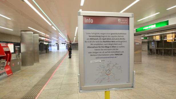 In einer U-Bahn-Station steht ein Schild mit Informationen zu Fahrplanänderungen.